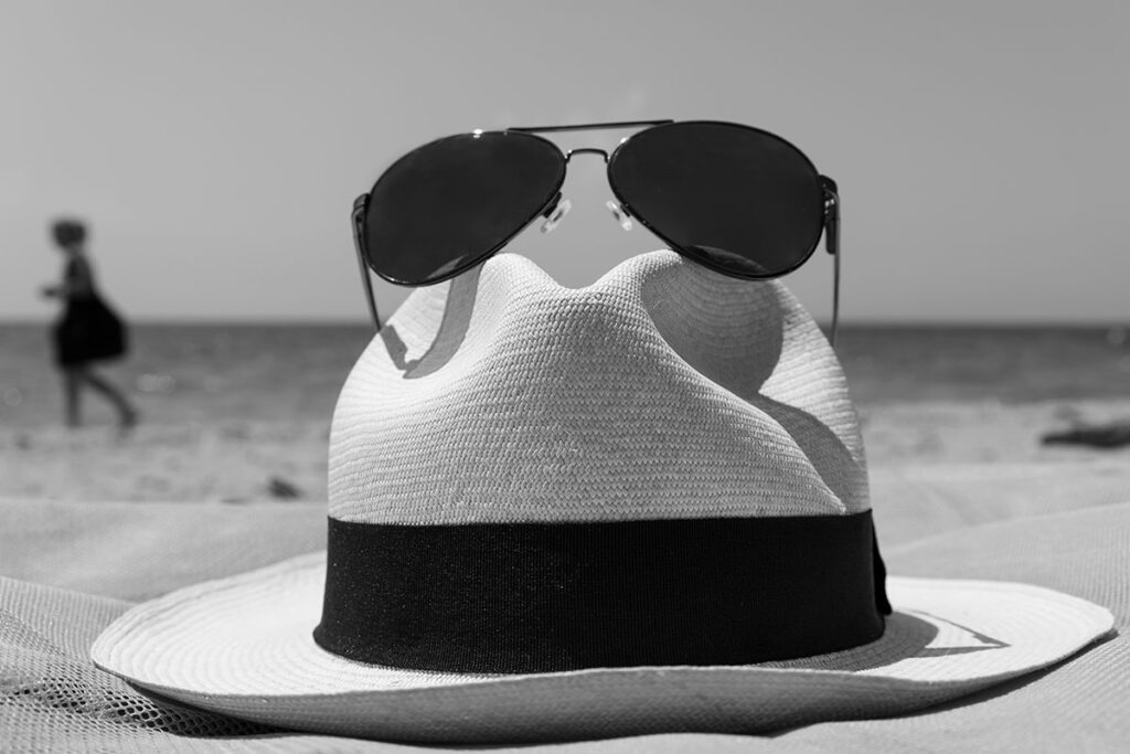 Panama hat and sunglasses on a beach